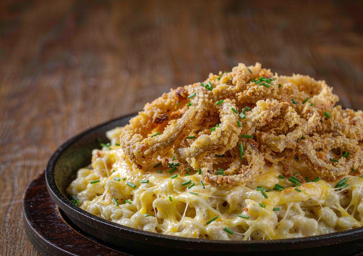 German Kaesespaetzle in a cast-iron skillet with melted cheese and crisp fried onions on top