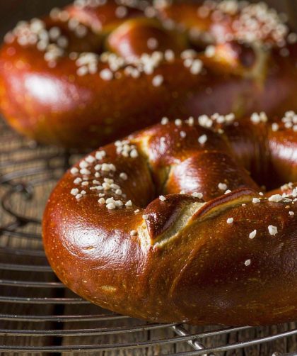 Freshly baked German soft pretzels with dark brown crusts and coarse salt on a wire rack