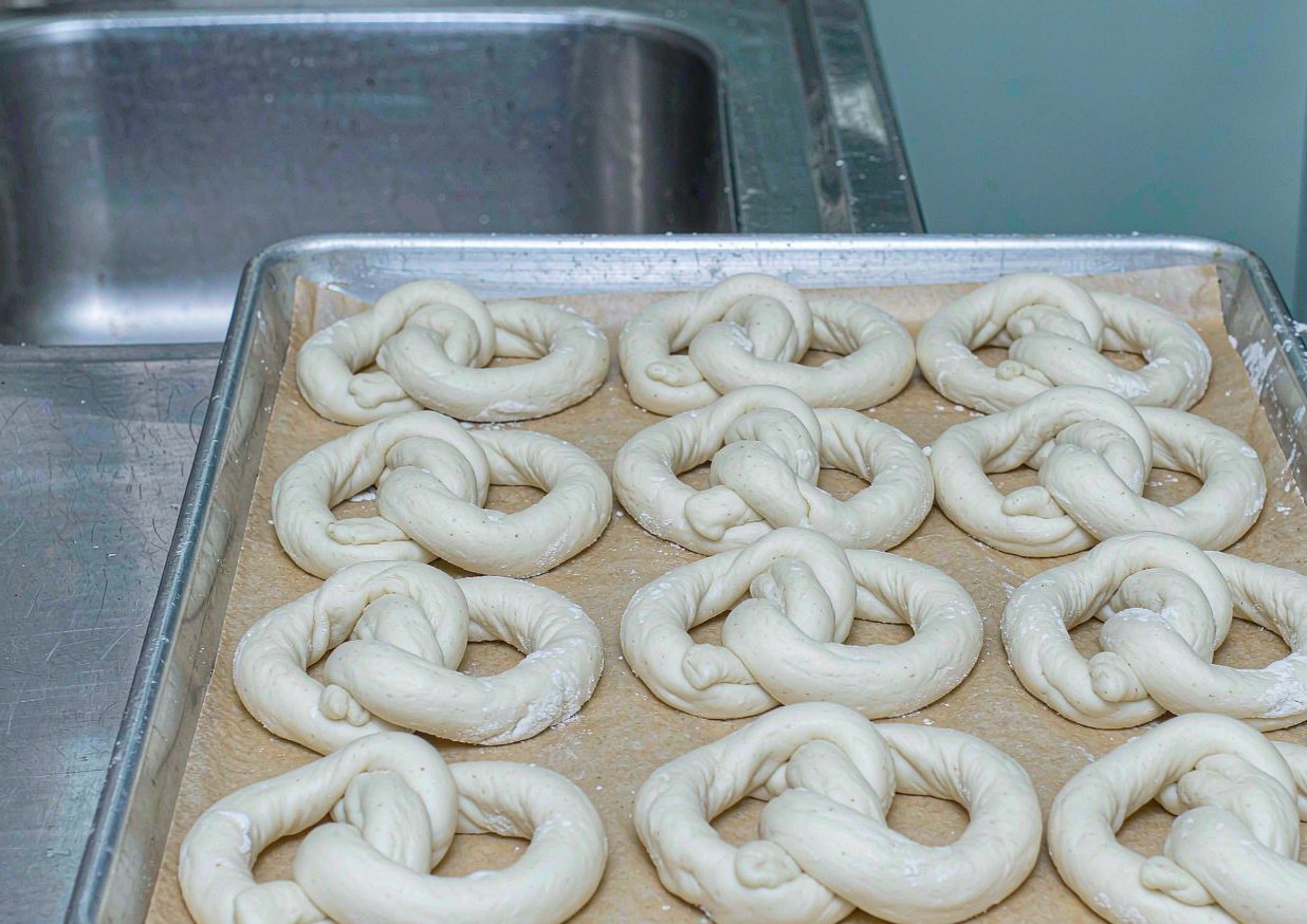 Shaped raw pretzel dough resting on a parchment-lined tray before the alkaline dip